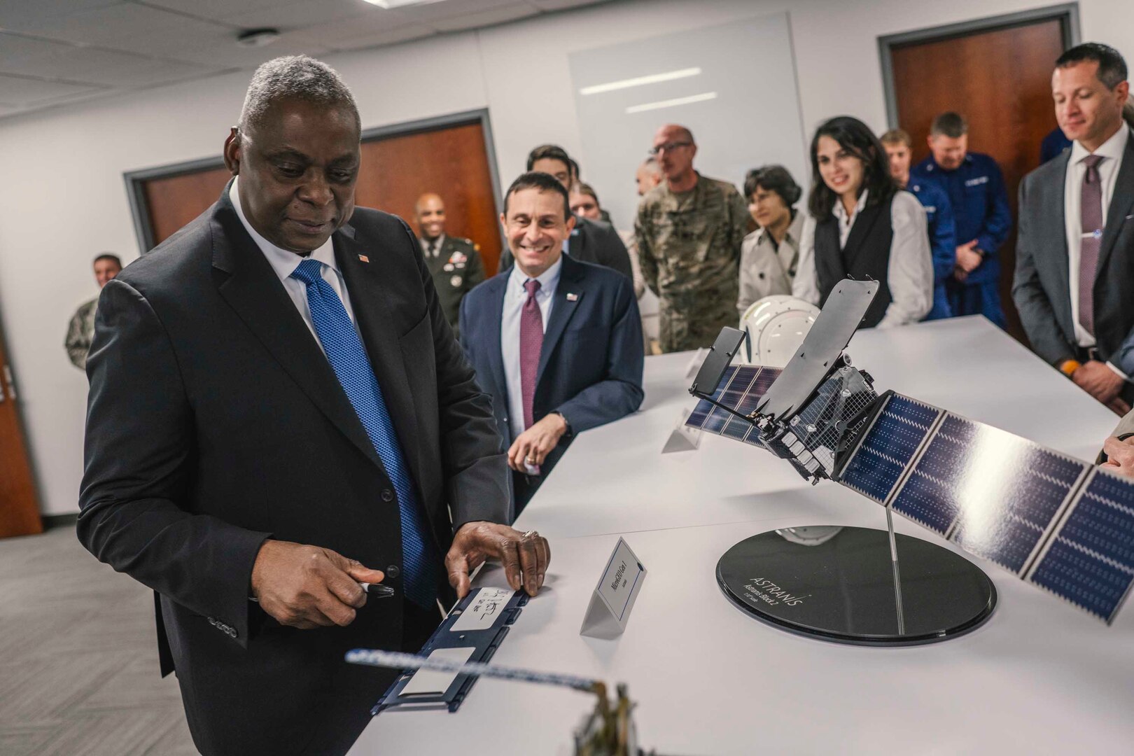 A man in business attire observes a technology display.