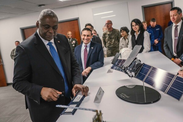 A man in business attire observes a technology display.