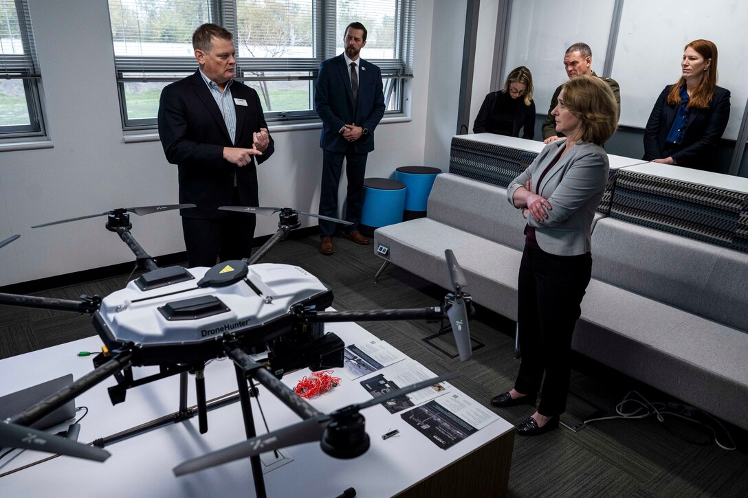 A woman in business attire observes a technology display.