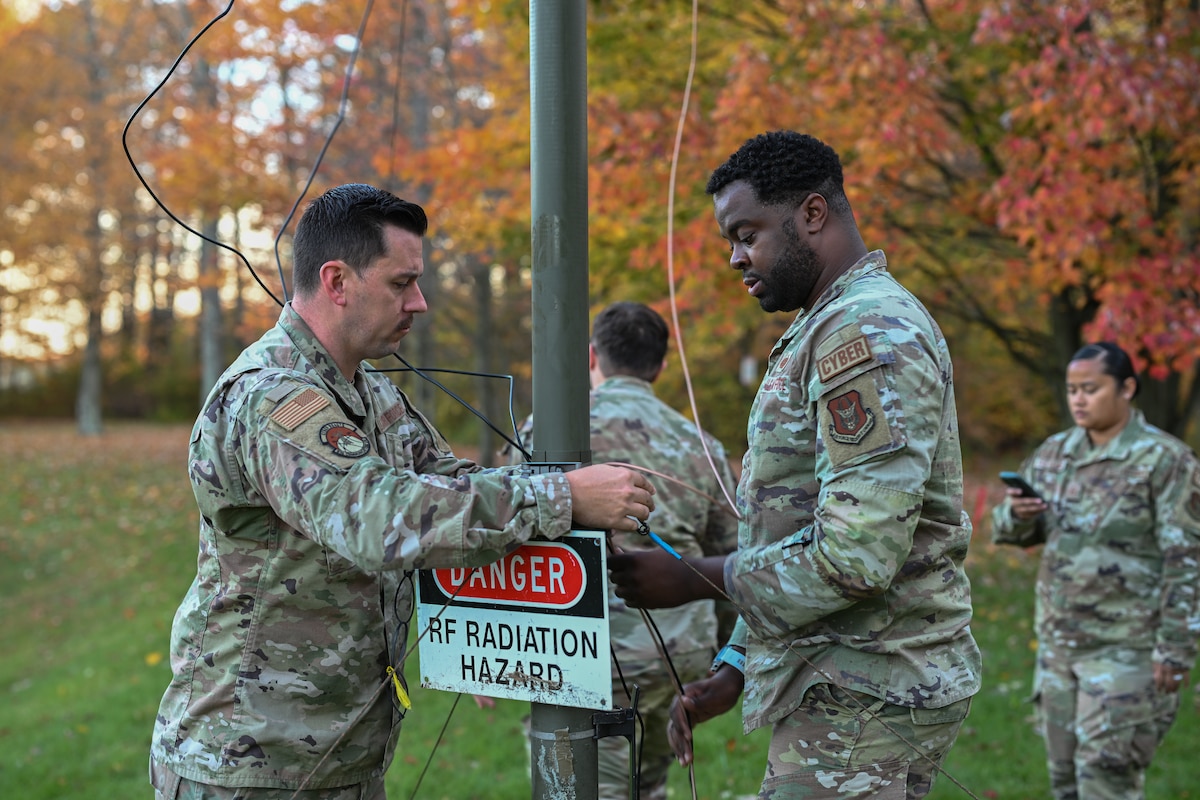 Tech. Sgt. Joshua Powell (left) and Tech. Sgt. Malik Flowers (center), RF systems operations supervisors assigned to the 910th Communications Squadron, adjust a high-frequency radio system antenna while Master Sgt. Michelle Guevarra (right), NCOIC of RF transmissions operations, coordinates with other teams during Exercise Noble Skywave at Youngstown Air Reserve Station, Ohio, Oct. 25, 2024.