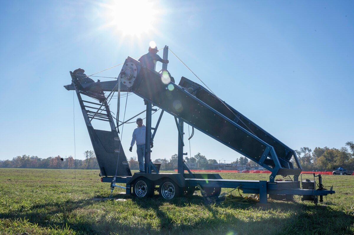 A large catapult for pumpkins sitting in a field.