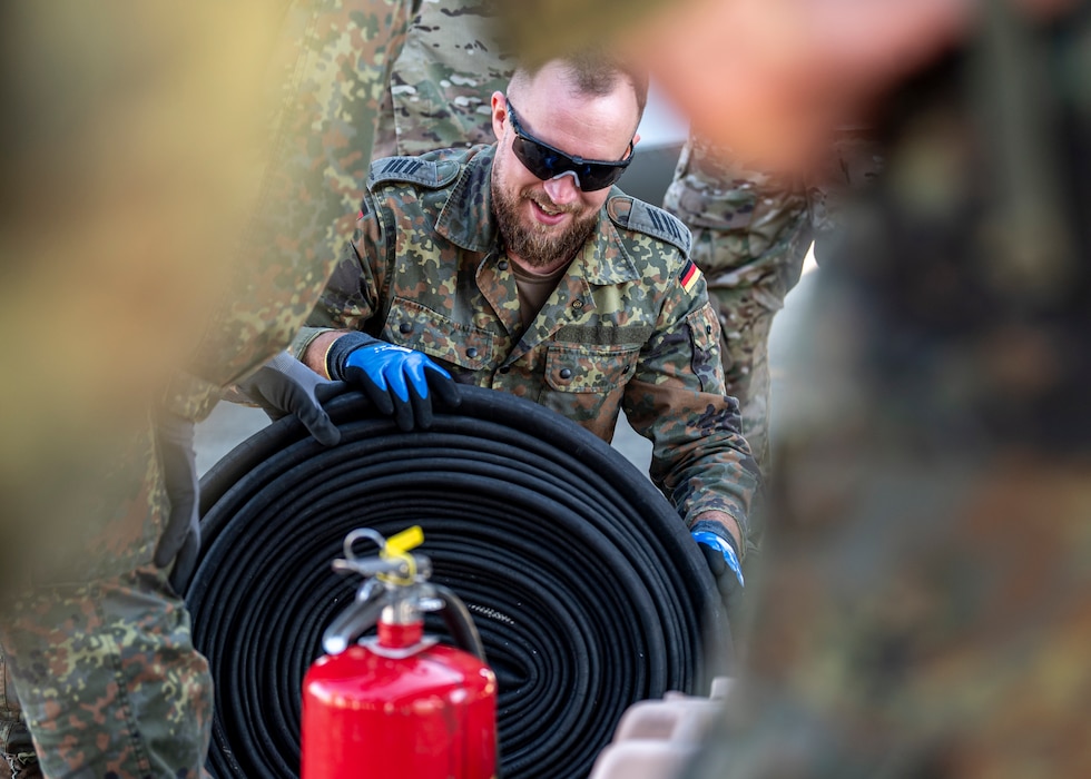 A German military member rolls a fuel hose at Moody Air Force Base, Georgia, Oct. 23, 2024. Moody AFB Airmen demonstrated rapid refuel techniques to hone German and U.S. Agile Combat Employment capabilities . (U.S. Air Force photo by Senior Airman Leonid Soubbotine)