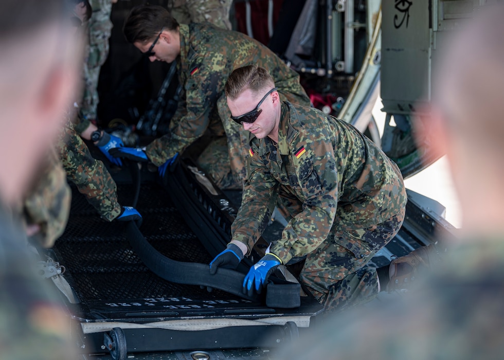 German military members pack a fuel hose at Moody Air Force Base, Georgia, Oct. 23, 2024, during a Forward Area Refueling Point training event. Precise positioning of the hoses allows for rapid deployment of fuel during operations in an austere environment. (U.S. Air Force photo by Senior Airman Leonid Soubbotine)