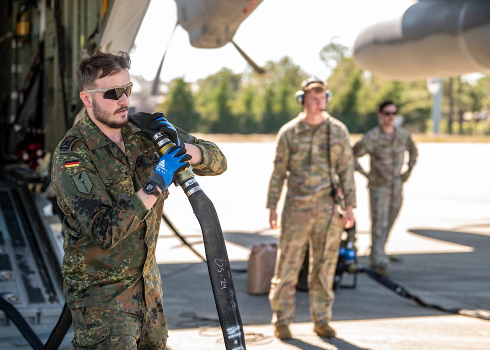 A German military member carries a fuel hose at Moody Air Force Base, Georgia, Oct. 23, 2024. Forward Area Refueling Point techniques utilize specialized equipment and small groups of trained military members to rapidly refuel aircraft in austere locations. (U.S. Air Force photo by Senior Airman Leonid Soubbotine)