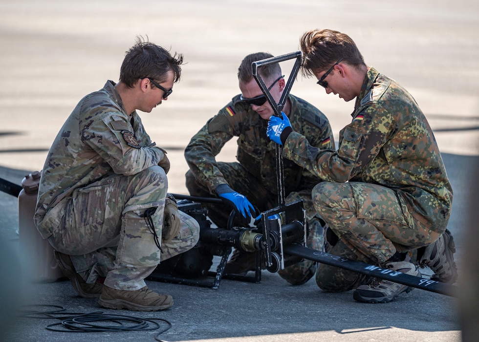 U.S. Air Force Staff Sgt. John Wheeler, 71st Rescue Squadron loadmaster, works with German military members at Moody Air Force Base, Georgia, Oct. 23, 2024, during a refueling training event. Wheeler explained the use of the specialized Forward Area Refueling Point equipment and demonstrated their use. (U.S. Air Force photo by Senior Airman Leonid Soubbotine)