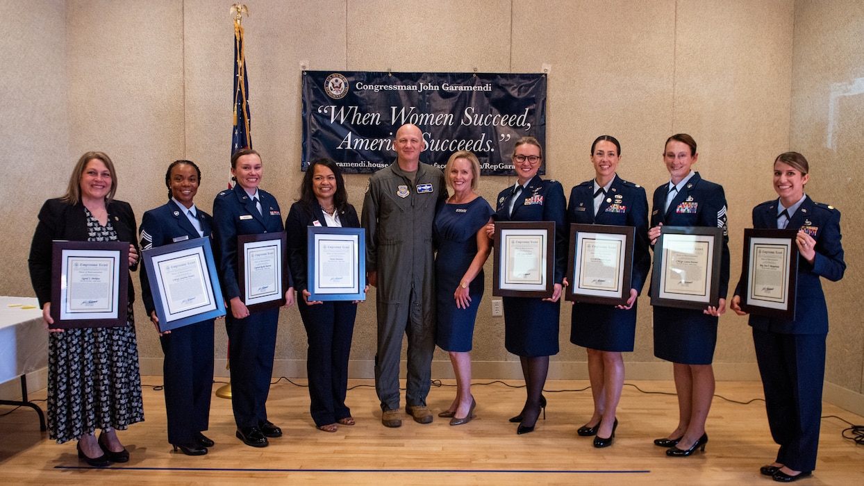 Commander poses with award recipients