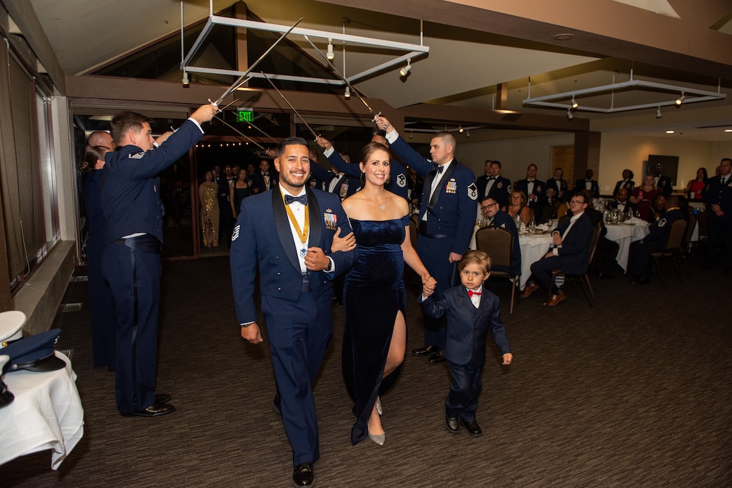 U.S. Airman and family walking under swords