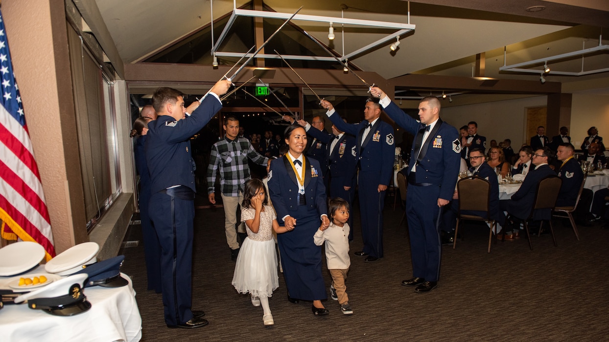 U.S. Airman and family walking under swords