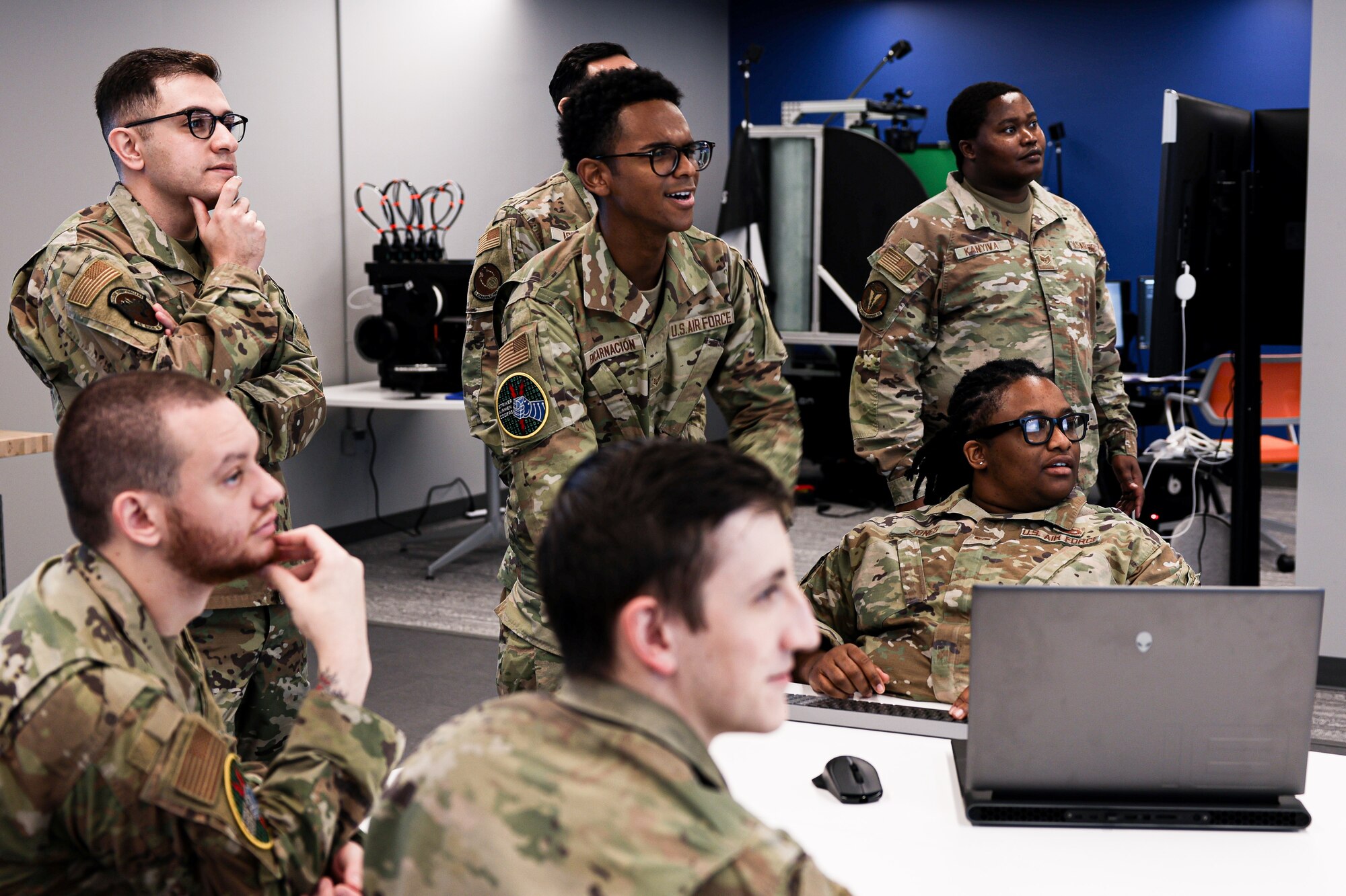 People are either standing or sitting around a desk
