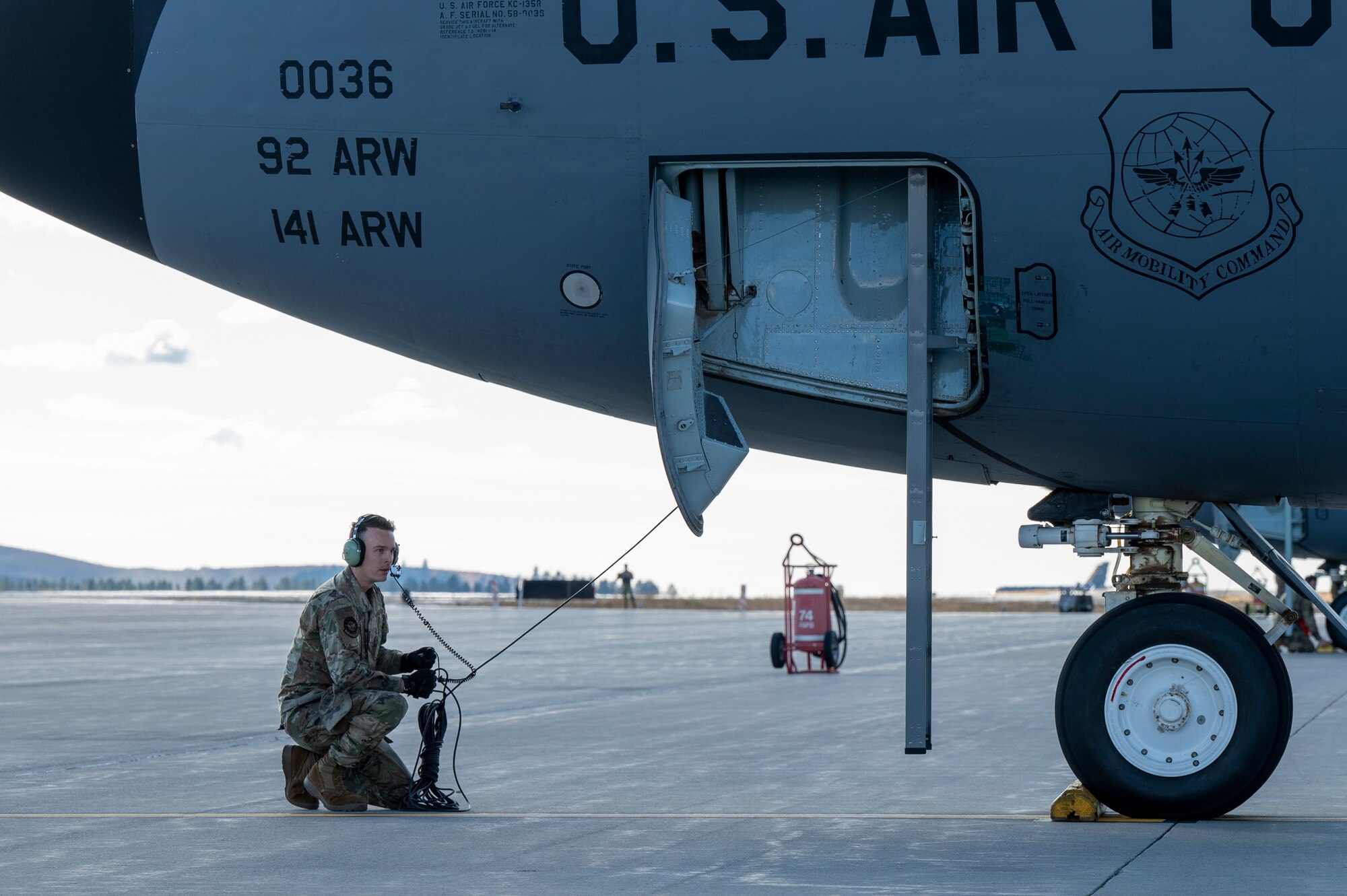 A U.S. Air National Guardsman assigned to the 116th Air Refueling Squadron communicates with aircrew as part of pre-flight checks during exercise Mobility Response 25 in support of U.S. Strategic Command exercise Global Thunder 25 at Fairchild Air Force Base, Washington, Oct. 22, 2024. Airmen performed pre-flight checks ensuring the electrical systems inside the aircraft are functioning correctly. The KC-135 Stratotanker played a crucial role in this exercise and GT25, providing essential air-to-air refueling capabilities, that are vital for sustaining long-range operations. (U.S. Air Force photo by Airman 1st Class Samantha Thorn)