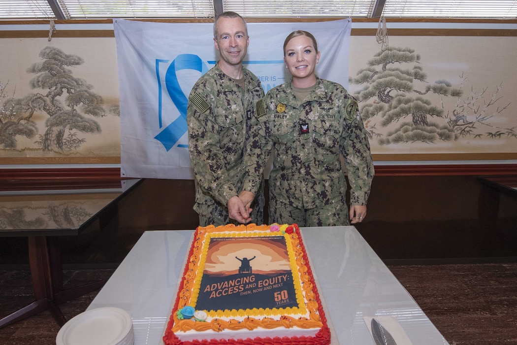 Command Master Chief Dennis Hunt and Master-at-Arms 2nd Class Katarina Rowley, assigned to Commander, Fleet Activities Yokosuka (CFAY), cut the ceremonial cake during a National Disability Employment Awareness Month luncheon at the installation’s Commodore Matthew C. Perry General Mess, Oct. 18, 2024.