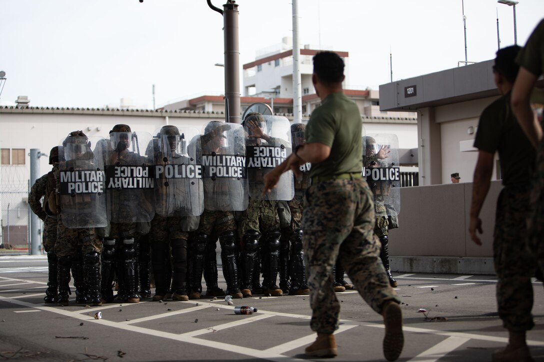 U.S. Marines with Headquarters and Headquarters Squadron, Marine Corps Air Station Iwakuni, create a shield barrier as a response to a simulated riot during exercise Keen Sword 25 at MCAS Iwakuni, Japan, Oct. 25, 2024. KS 25 is a biennial, joint and bilateral field-training exercise involving U.S. military and Japan Self-Defense Force personnel, designed to increase readiness and interoperability while strengthening the ironclad U.S.-Japan alliance. (U.S. Marine Corps photo by Sgt. Isaac Orozco)