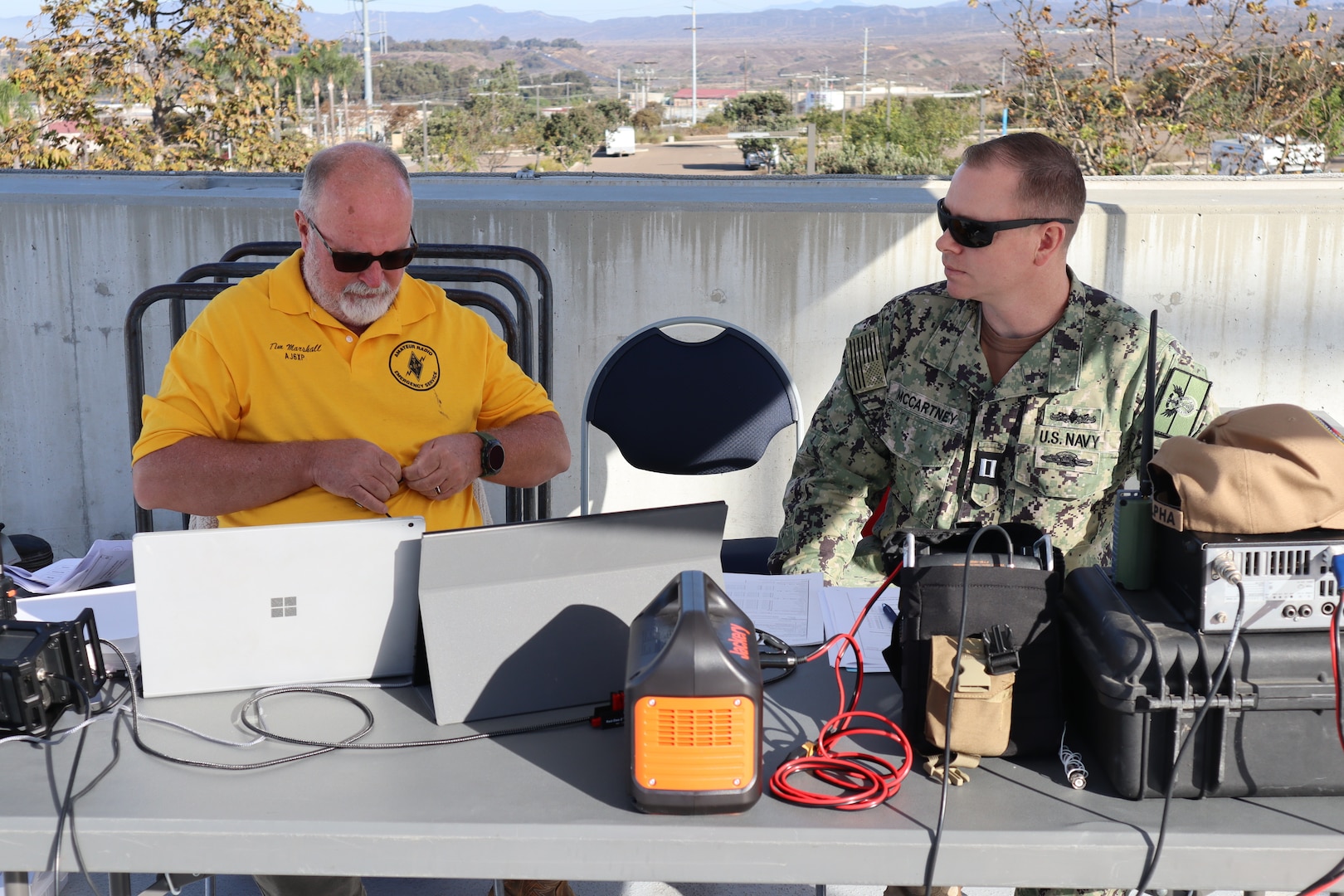 Tim Marshall, a volunteer with ARES and a retired Navy chief petty officer, and Navy Lt. Arion McCartney, Naval Hospital Camp Pendleton Chief Information Officer, discuss amateur radio procedures during the San Diego County 2024 Pediatric Surge Full Scale Exercise on Oct. 24, 2024, aboard Marine Corps Base Camp Pendleton. The hospital’s goals were to practice communication support during an event with degraded communication assets and to stress interoperability and collaboration with other agencies across the county. “We successfully achieved our objectives during this exercise by seamlessly integrating ARES volunteers into our emergency response framework, enabling efficient backup communication, enhancing resource coordination, and providing real-time situational awareness,” said McCartney. “Our successful collaboration with ARES volunteers and partner agencies demonstrated our ability to effectively manage a large-scale disaster scenario, ensuring that critical information and resources were available to support healthcare facilities and protect our community.”