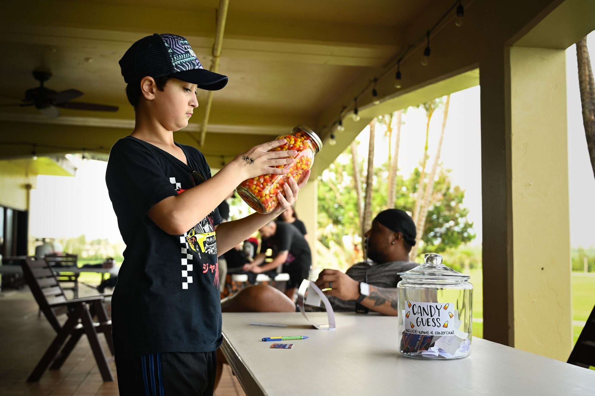 A attendee picks up a jar of candy corn pieces and guesses how many there are.
