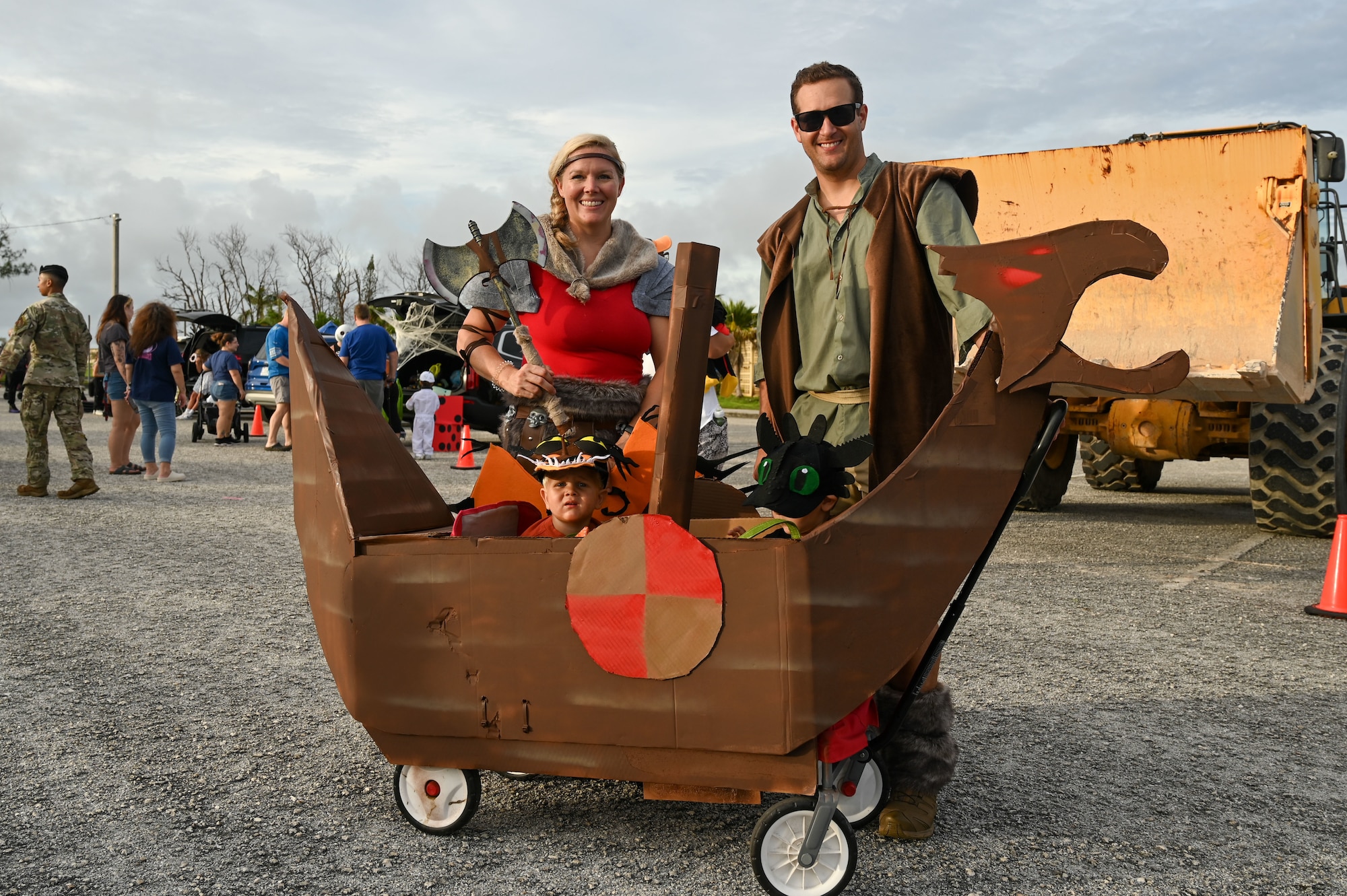 A family is dressed in Viking attire and a little black dragon as they pose for a photo.