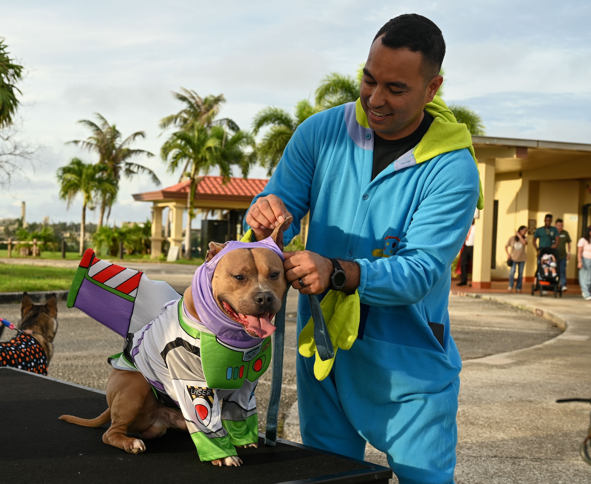 A attendee dresses his dog in a Buzz Lightyear costume.