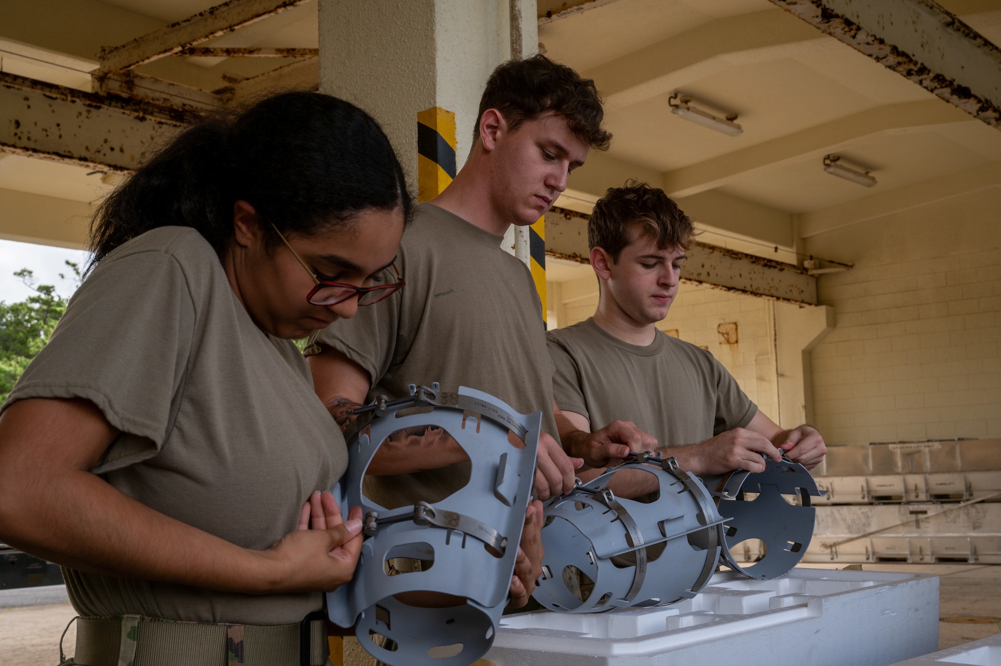 Airmen assembling an inert bomb using a joint direct attack munition guidance tail kit