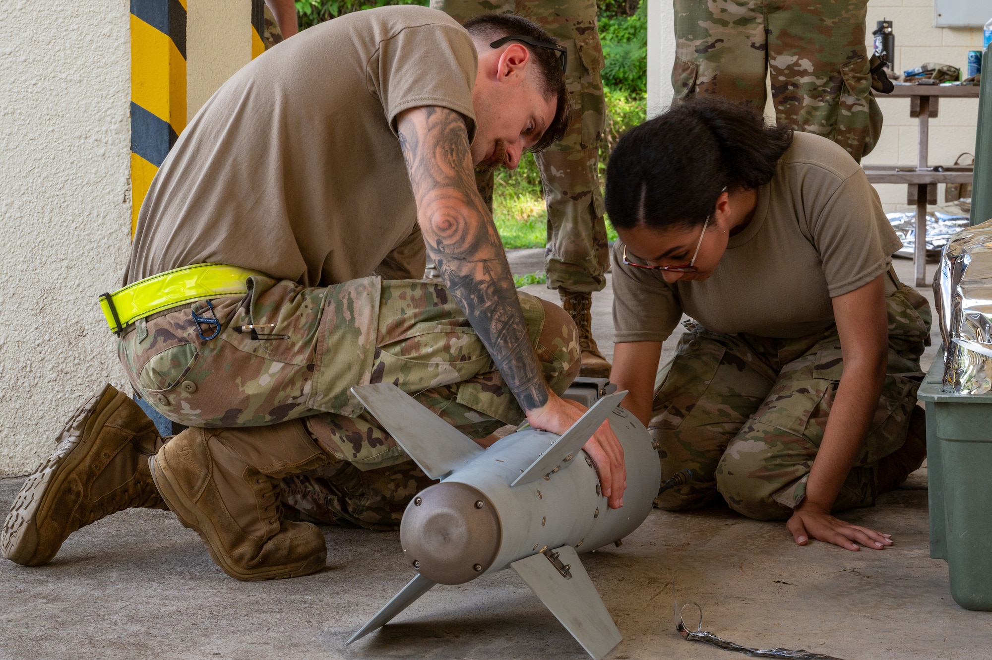 Airmen assembling an inert bomb using a joint direct attack munition guidance tail kit