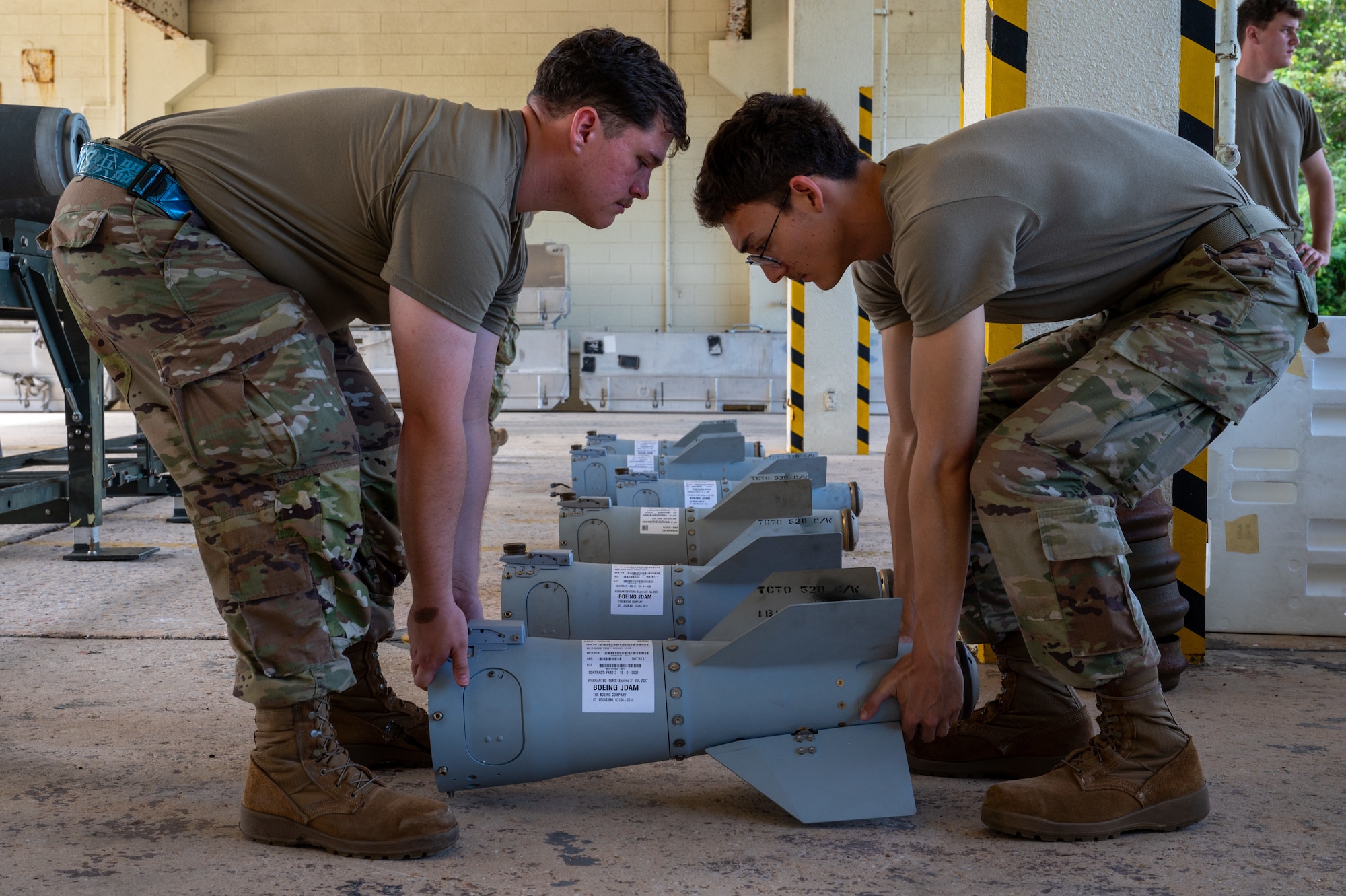 Airmen assembling an inert bomb using a joint direct attack munition guidance tail kit