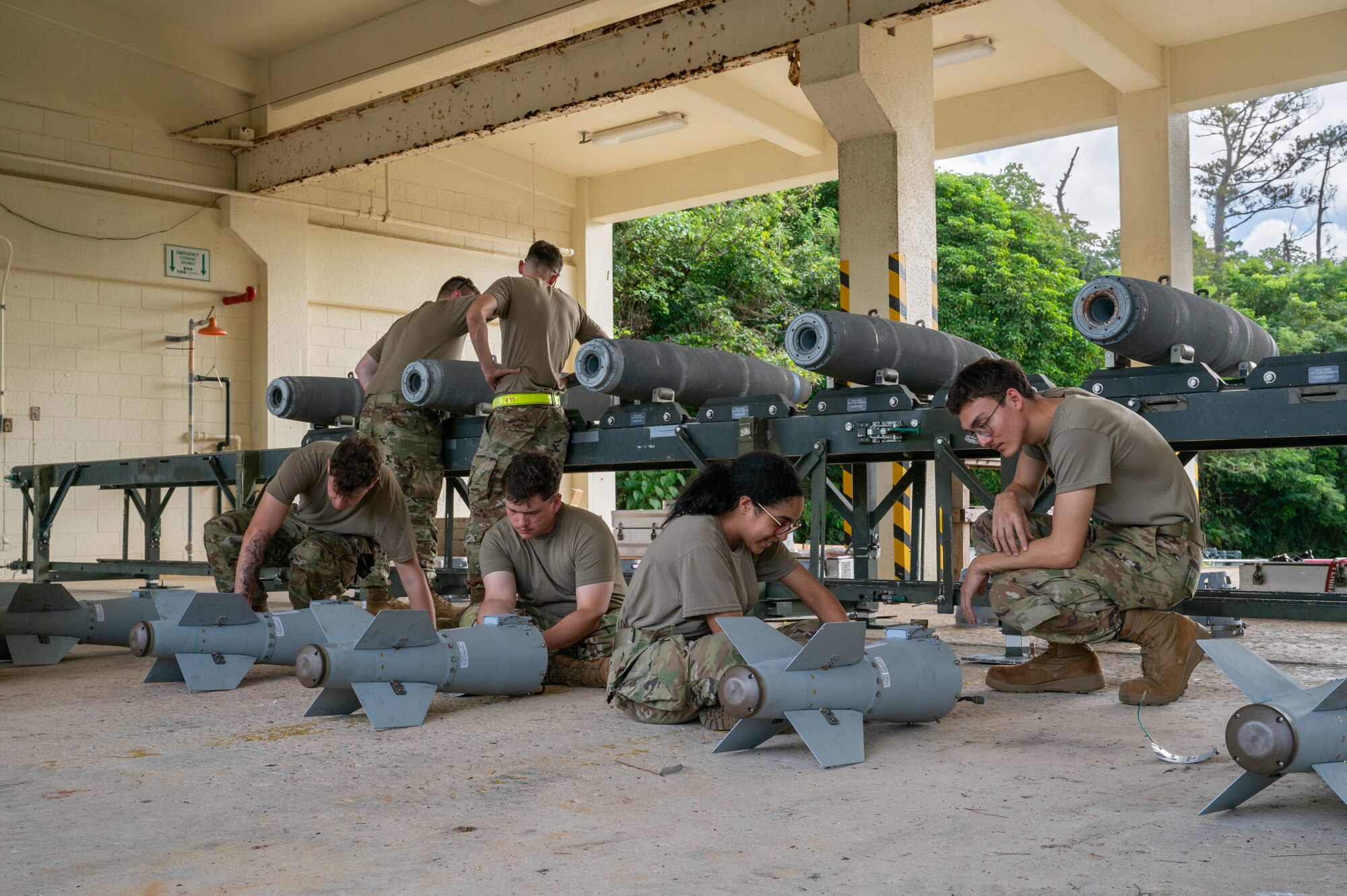 Airmen assembling an inert bomb using a joint direct attack munition guidance tail kit