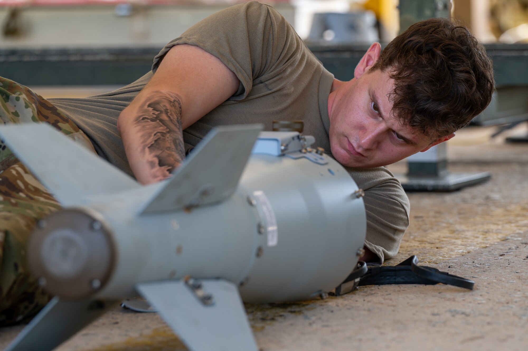 Airmen assembling an inert bomb using a joint direct attack munition guidance tail kit