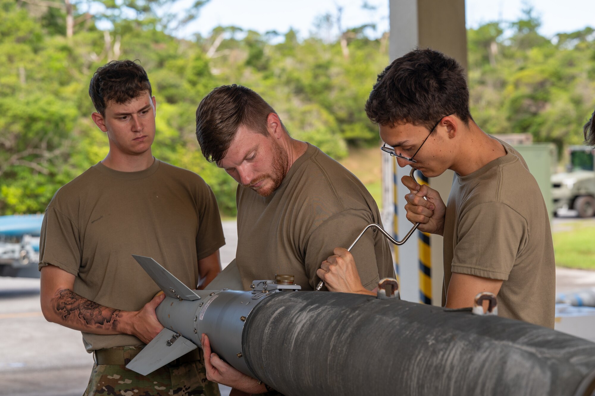 Airmen assembling an inert bomb using a joint direct attack munition guidance tail kit