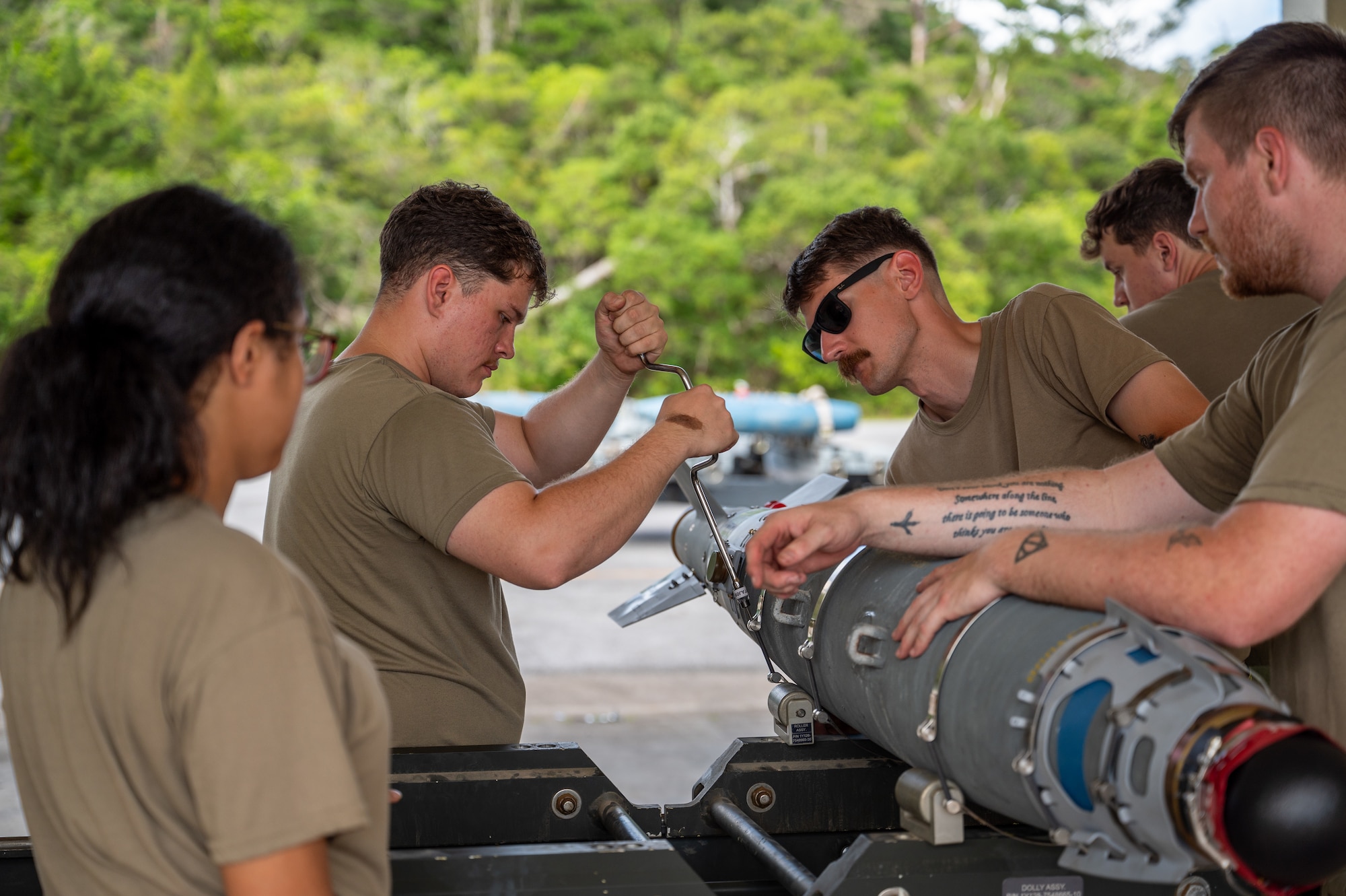 Airmen assembling an inert bomb using a joint direct attack munition guidance tail kit