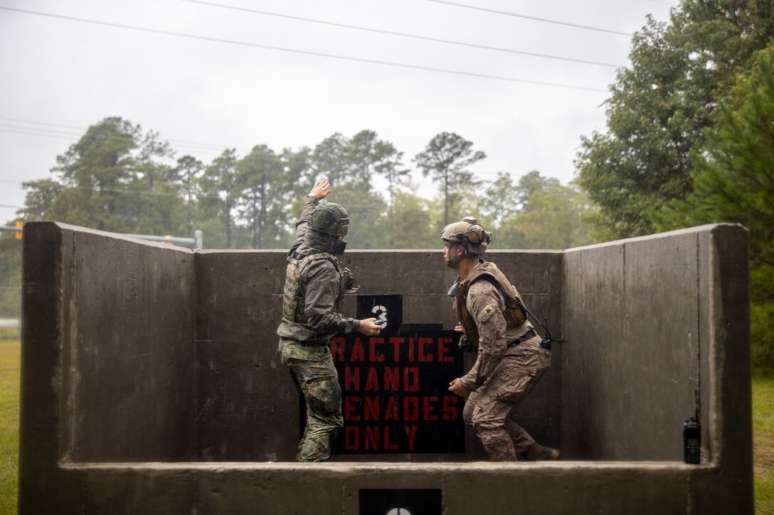 U.S. Marine Corps Sgt. Christopher Andujarmayas, right, a data system administrator with 2nd Air Naval Gunfire Liaison Company, II Marine Expeditionary Force Information Group, instructs a Finnish service member on proper grenade throwing techniques during Burmese Chase 24 at Marine Corps Base Camp Lejeune, North Carolina, Sept. 16, 2024. Burmese Chase is an annual U.S. led, multi-lateral exercise that includes training on integration of ground and air fires, infantry tactics and naval gunfire alongside NATO allies. (U.S. Marine Corps photo by Cpl. Jacquilyn Davis)