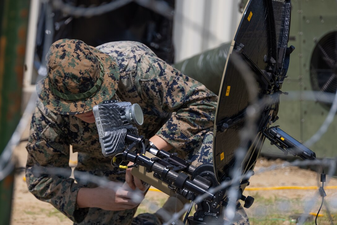 U.S. Marine Corps Cpl. Chance A. Lyster, a satellite transmission system operator with 8th Communication Battalion, II Marine Expeditionary Force Information Group, inspects a Multi-Mission Terminal satellite during a II MEF exercise at Marine Corps Auxiliary Landing Field, Bogue, North Carolina, Aug. 15, 2024. The purpose of the exercise is to provide II Marine Expeditionary Force the opportunity to rehearse command and control capabilities in a tactical environment. (U.S. Marine Corps photo by Lance Cpl. Alexander Hires)