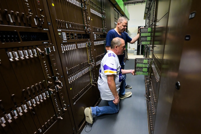 Burke Kilburn and Phil Gardner, 75th Communications and Information Directorate, look at deactivated analog telecommunications components at Hill Air Force Base, Utah. The directorate transitioned to a fully digital system that requires less resources to manage while providing more capabilities.