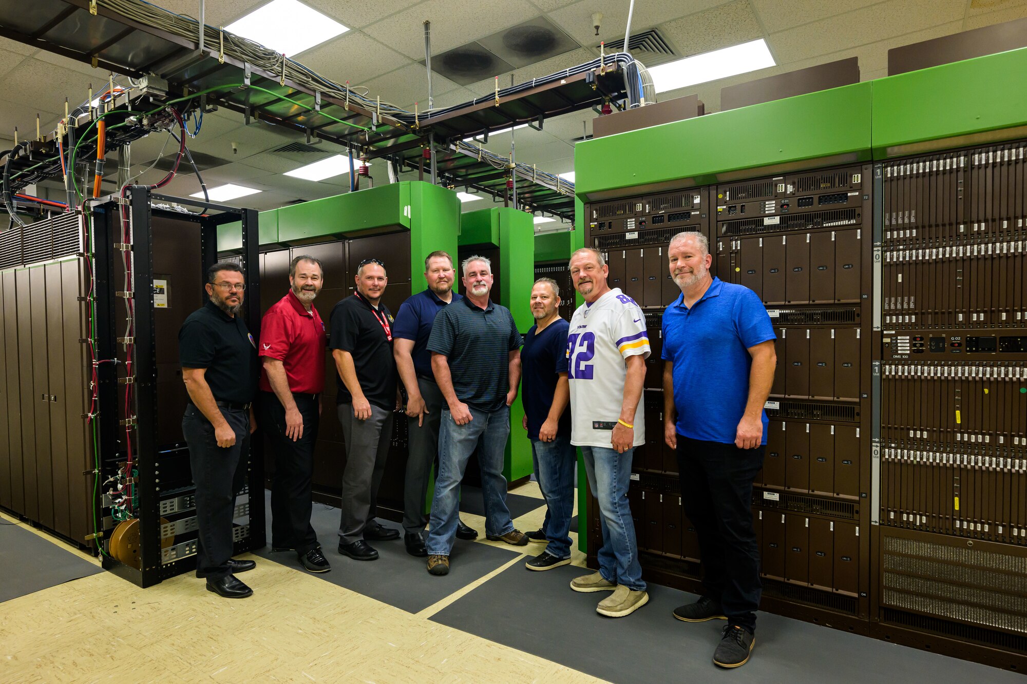 Members of the 75th Air Base Wing Communications and Information Directorate stand in front of a deactivated analog telecommunications system at Hill Air Force Base, Utah. The directorate transitioned to a fully digital system that requires less resources to manage while providing more capabilities.