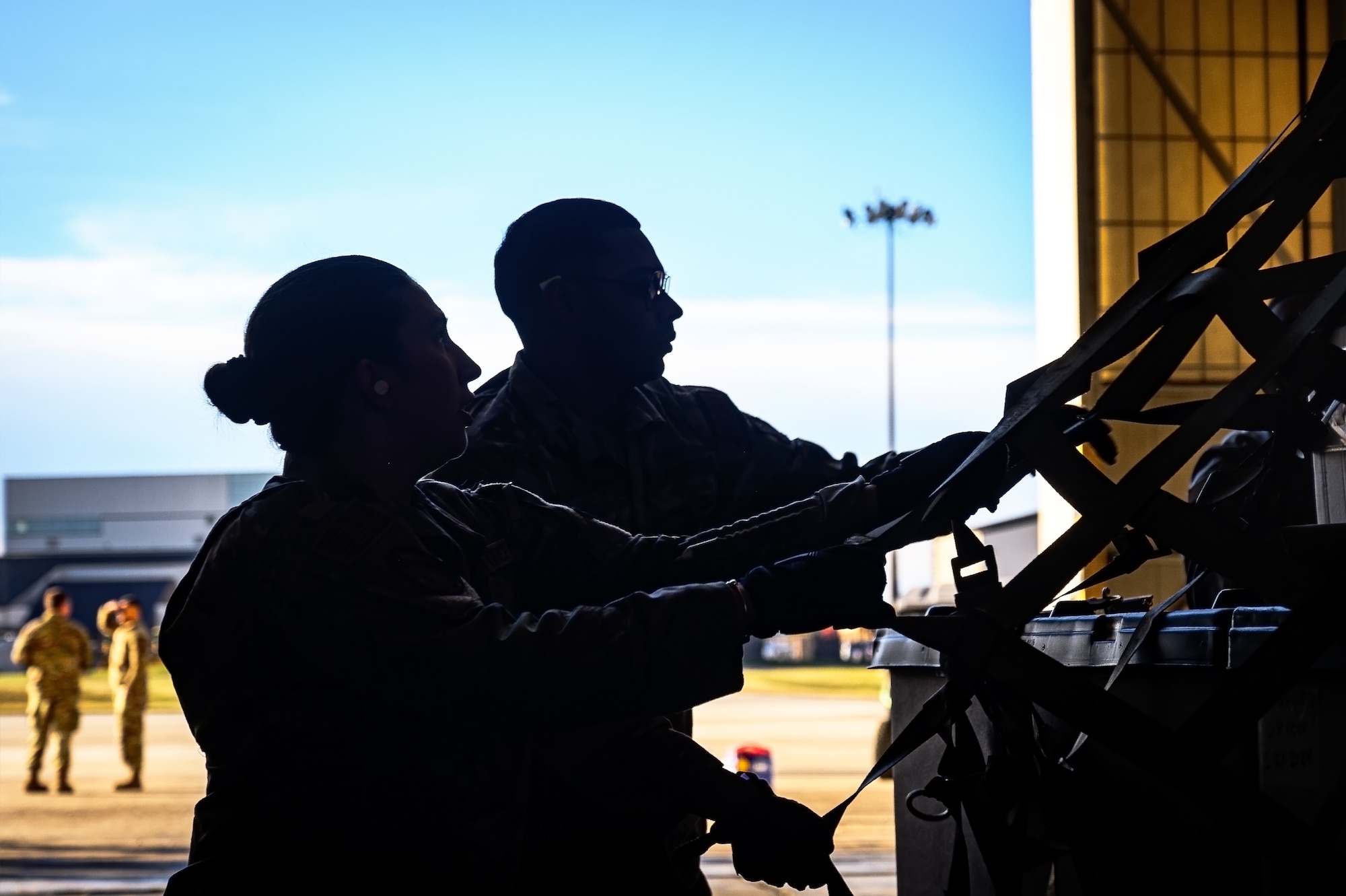 U.S. Air Force Senior Airman Hannah Shattuck, 305th Aerial Port Squadron transportation specialist, and U.S. Air Force Airman 1st Class Marcos Ortiz-Querol, 305th APS transportation specialist, secure a pallet during the APS Rodeo at Joint Base McGuire-Dix-Lakehurst, N.J., Oct. 17, 2024. The APS Rodeo is an annual event held to showcase top performers in an array of transportation challenges that simulate what it is like to work in a high-tempo environment. (U.S. Air Force photo by Senior Airman Matt Porter)