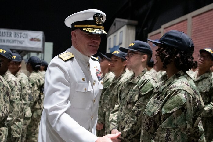 Rear Adm. Oliver "Ollie" Lewis Trayer, director, strategic integration, congratulations new Sailors in front of USS Trayer (BST-21) during a capping ceremony at Recruit Training Command (RTC). Trayer, more commonly referred to as "Battle Stations," is the crucible event that recruits must pass prior to graduation, testing their knowledge and skills in basic seamanship, damage control, firefighting and emergency response procedures. More than 40,000 recruits train annually at the Navy's only boot camp. (U.S. Navy photo by Mass Communication Specialist 1st Class John Suits)