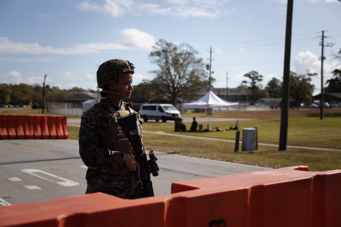 U.S. Marine Corps Cpl. Ruth Polancorivera, a legal services specialist with Headquarters and Support Battalion (H&S Bn), Marine Corps Installations East-Marine Corps Base (MCB) Camp Lejeune, stands guard during Exercise Urgent Response on MCB Camp Lejeune, North Carolina, Oct. 23, 2024. H&S Bn Marines conducted identification verification and established vehicle control points in support of Exercise Urgent Response, an installation-wide exercise that provides realistic training opportunities to increase the installation’s emergency response efforts, command and control, and security capabilities. (U.S. Marine Corps photo by Sgt. Khalil Brown)