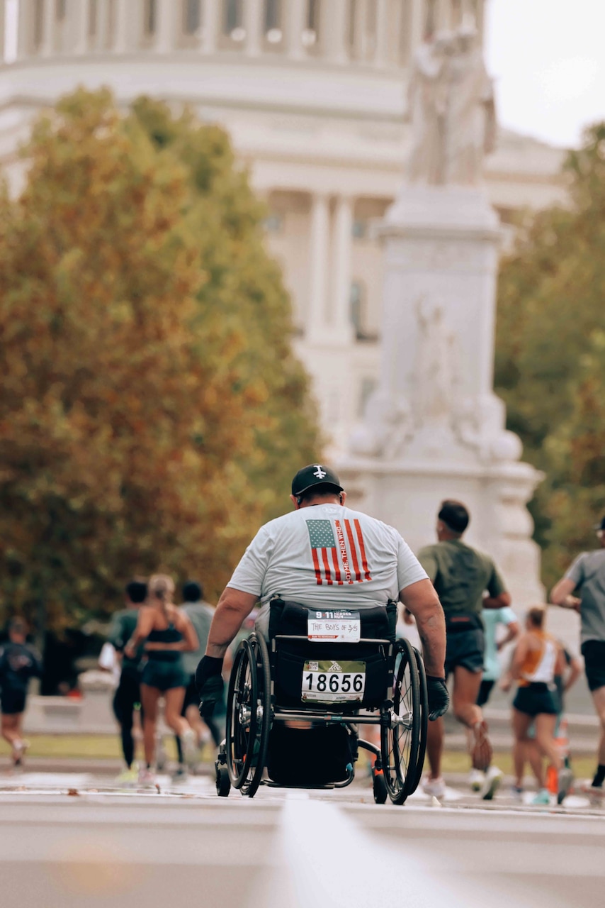 A person in a wheelchair moves down a road.