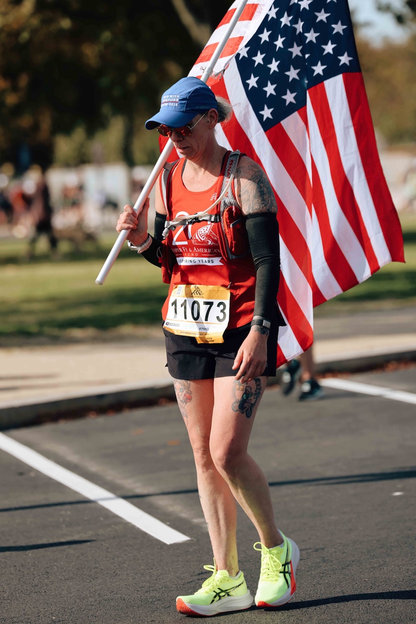 A runner walks while holding a flag.
