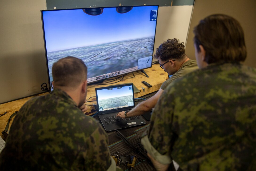 U.S. Marine Corps Sgt. Brendan Smith, right, joint terminal attack controller with 2nd Air Naval Gunfire Liaison Company, II Marine Expeditionary Force Information Group, teaches how to operate the JTAC virtual trainer to NATO allied service members participating in exercise Burmese Chase 24 at Marine Corps Base Camp Lejeune, North Carolina, Sept. 5, 2024. Burmese Chase is an annual U.S. led, multi-lateral exercise that includes training on integration of ground and air fires, infantry tactics and naval gunfire alongside NATO allies. (U.S. Marine Corps photo by Cpl. Jacquilyn Davis)