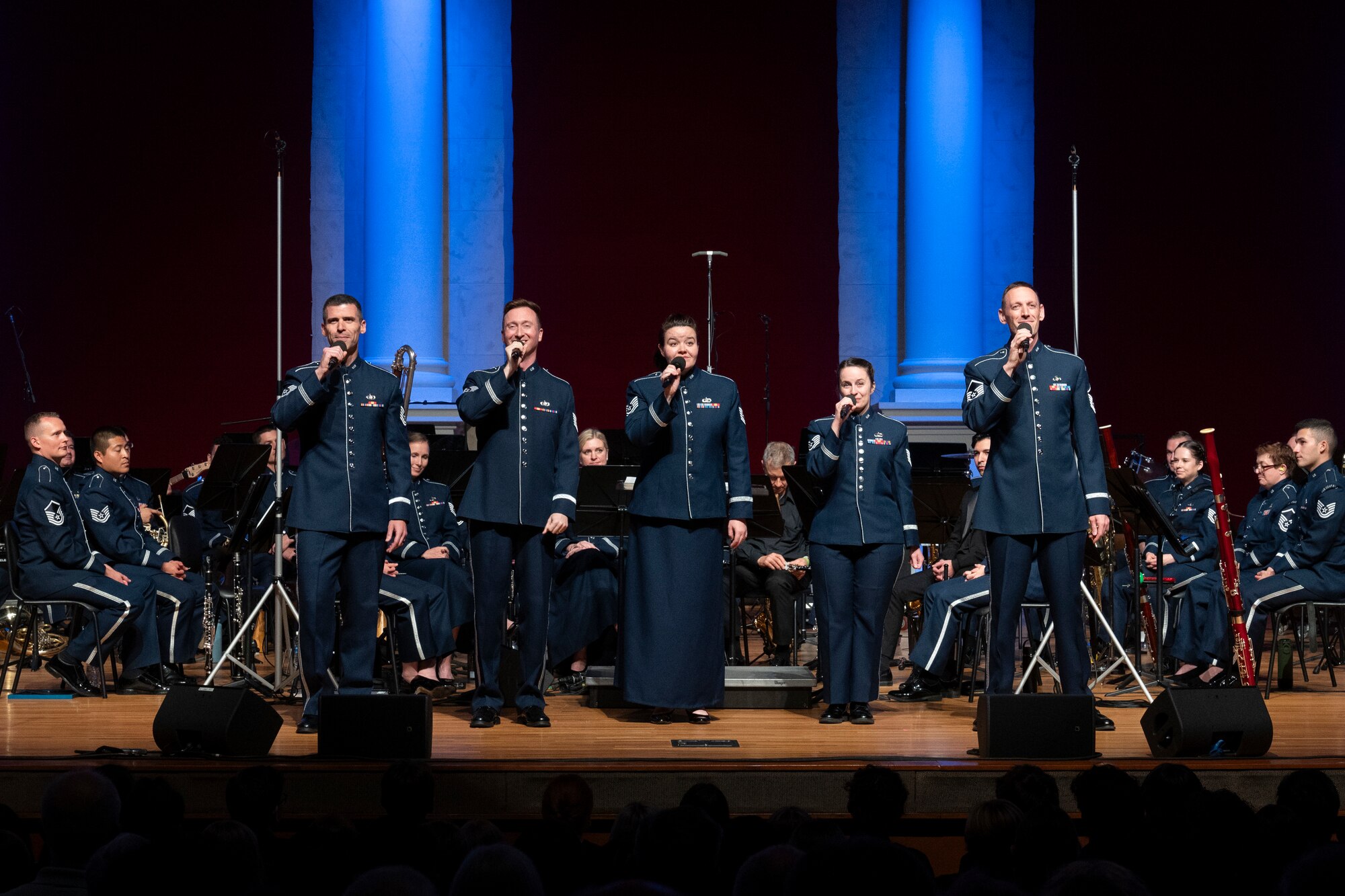 A band and singers perform on stage.