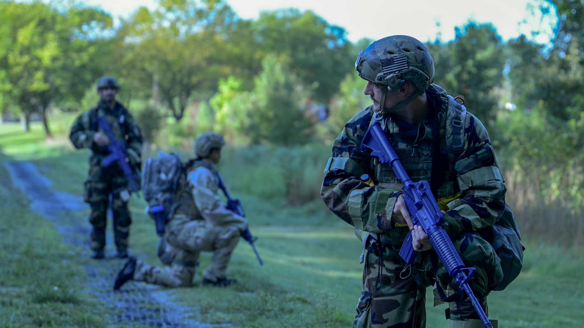 From front, U.S. Air Force Senior Airman Steven Fazakerley, training team member; 1st Lt. Maria Reffner, flight commander, Installation Office of Emergency Management; and Senior Airman Samuel Baker, operations team member, all assigned to the 316th Civil Engineer Squadron, conduct a patrol during a Chemical, Biological, Radiological, and Nuclear training exercise at Joint Base Andrews, Md., Aug. 23, 2024. The exercise focused on maneuvering in protective gear while maintaining situational awareness in simulated threat environments. (U.S. Air Force photo by Staff Sgt. Isaac March)