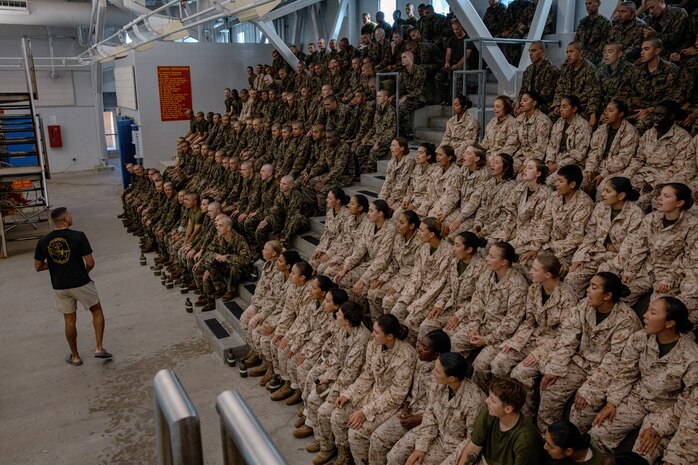 U.S. Marine Corps Sgt. Tysen Schmidt, a Marine Corps instructor of water survival, with Support Battalion, Recruit Training Regiment, gives a brief to recruits with Fox Company, 2nd Recruit Training Battalion, before they conduct a swim qualification event at Marine Corps Recruit Depot San Diego, California, Oct. 21, 2024. The basic swim qualification consists of a 25-meter swim, tower jump into the water, four-minute tread, 25-meter pack swim, and an underwater gear shed. (U.S. Marine Corps photo by Cpl. Sarah M. Grawcock)