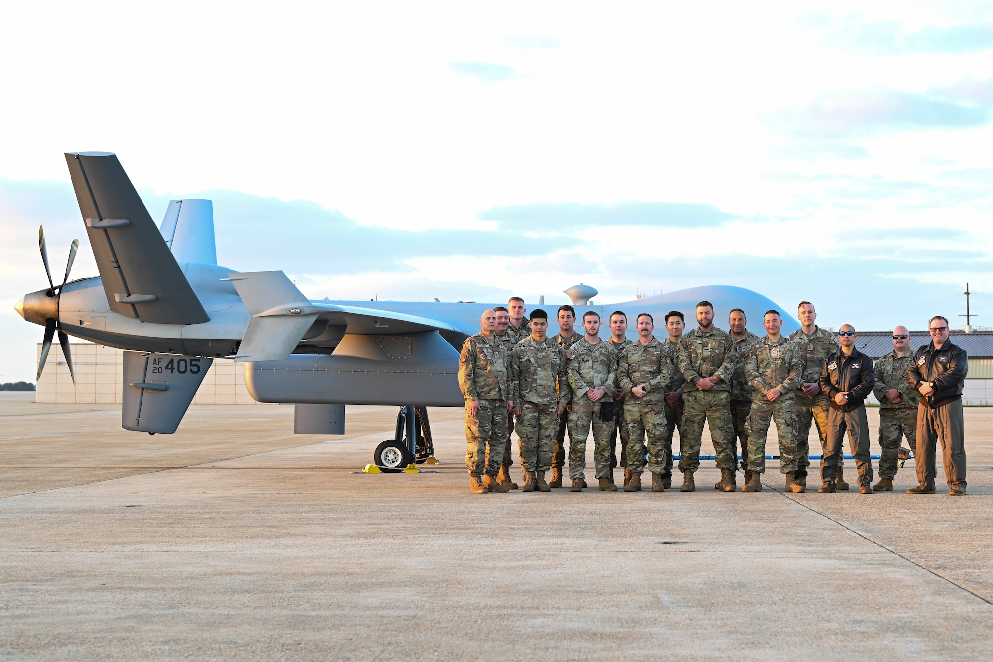 A group of Airmen gather for a photo after an MQ-9 Reaper lands in support of Freedom Flag 24-1.