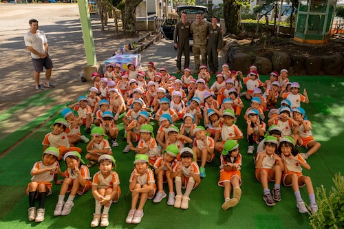 Airmen and students pose for a photo.