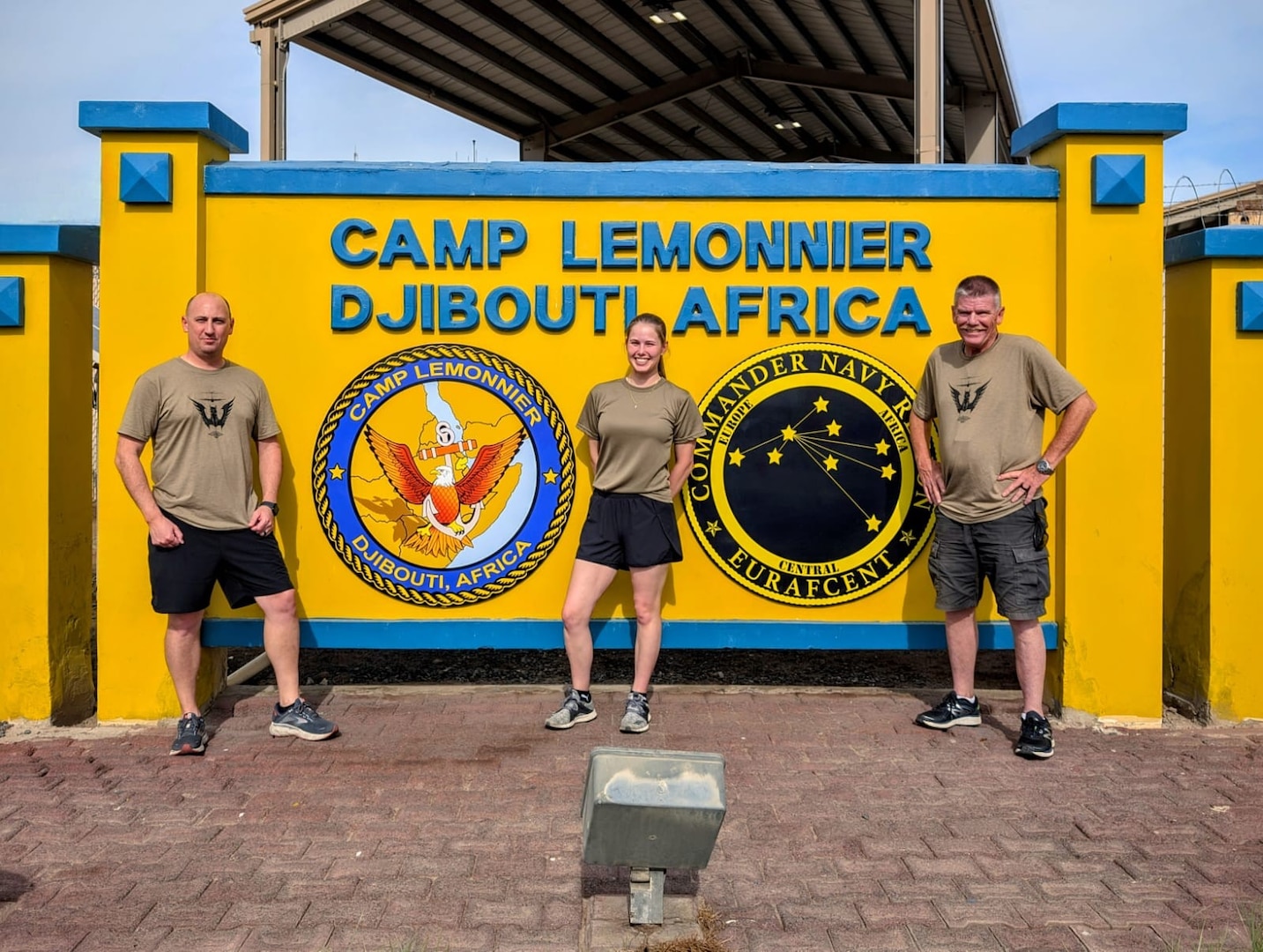 U.S. Air Force Lt. Col. Mathew Lehman, Staff Sgt. Jana Somero, and Senior Master Sgt. Stephen Berthiaume, all members of the 158th Fighter Wing, stand in front the sign for Camp Lemonnier