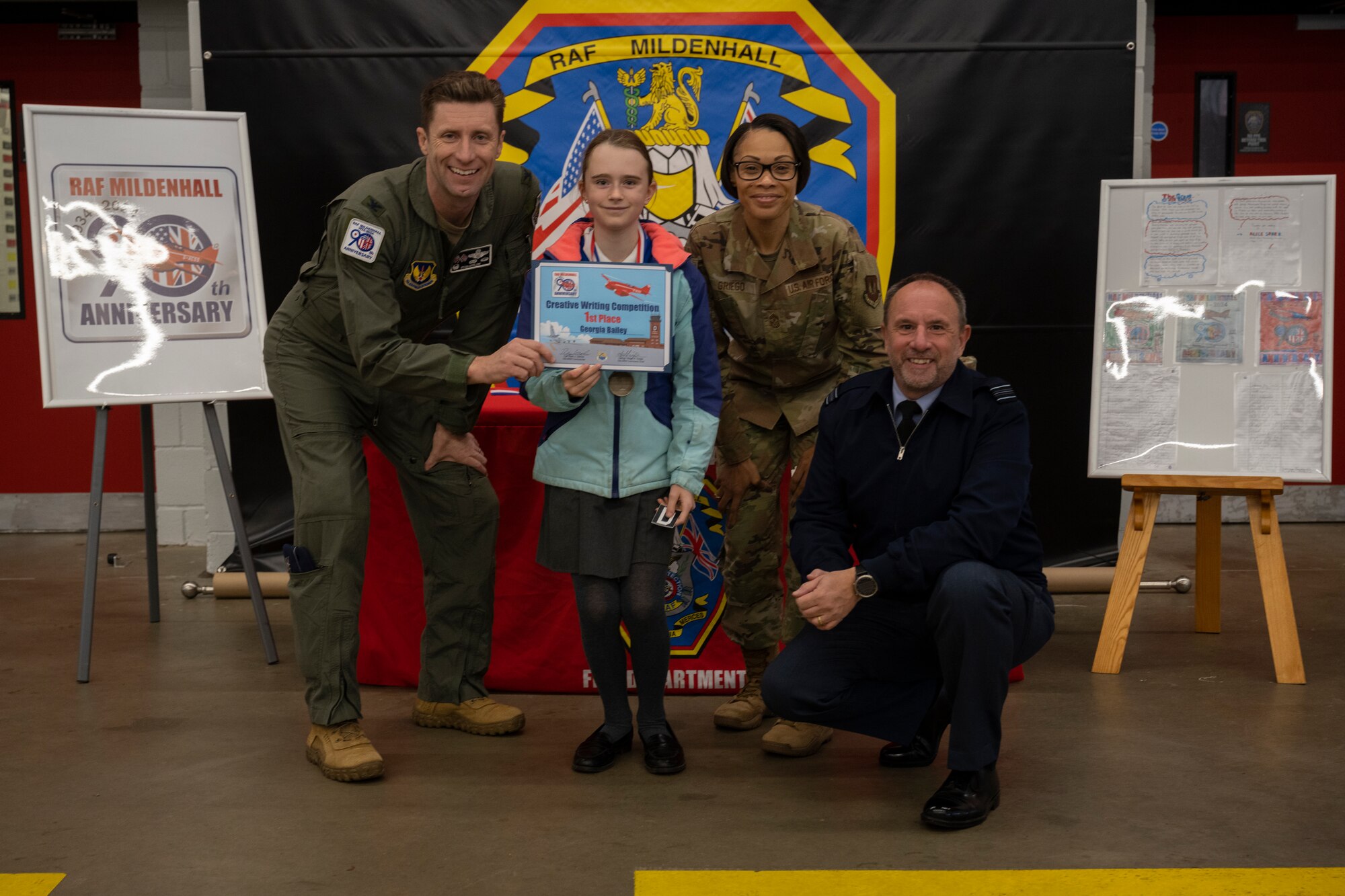 U.S. Air Force Col. Ryan Garlow, left, 100th Air Refueling Wing commander, competition winner, center left, Chief Master Sgt. Tiffany Griego, center right, 100th ARW command chief, and Royal Air Force Squadron Leader Andy Bell, right, RAF Mildenhall commander, pose for a photograph at RAF Mildenhall, England, Oct. 17, 2024.