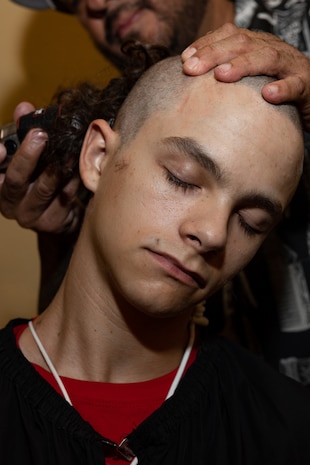 U.S. Marine Corps Recruit Jayden Alsin with Lima Company, 3rd Recruit Training Battalion, receives a haircut during a receiving event at Marine Corps Recruit Depot San Diego, California, Oct. 21, 2024. During the receiving process, recruits are checked for contraband, given haircuts, make scripted phone calls home, and are issued gear required for training. (U.S. Marine Corps photo by Lance Cpl. Janell B. Alvarez)