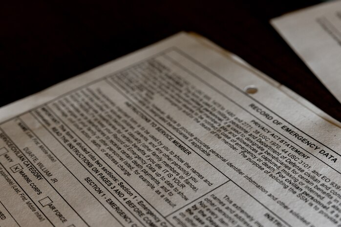 U.S. Marine Corps recruits with Lima Company, 3rd Recruit Training Battalion, receive  record of emergency data forms during a receiving event at Marine Corps Recruit Depot San Diego, California, Oct. 21, 2024. During the receiving process, recruits are checked for contraband, given haircuts, make scripted phone calls home, and are issued gear required for training. (U.S. Marine Corps photo by Lance Cpl. Janell B. Alvarez)