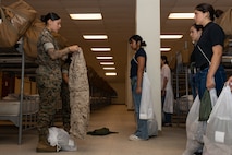 U.S. Marine Corps Cpl. Ashley Fiallo, a material handler with Headquarters and Service Battalion, briefs recruits with Lima Company, 3rd Recruit Training Battalion, during a receiving event at Marine Corps Recruit Depot San Diego, California, Oct. 21, 2024. During the receiving process, recruits are checked for contraband, given haircuts, make scripted phone calls home, and are issued gear required for training. (U.S. Marine Corps photo by Lance Cpl. Janell B. Alvarez)