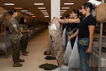 U.S. Marine Corps Cpl. Amanda Pimentel, a warehouse clerk with Headquarters and Service Battalion, briefs recruits with Lima Company, 3rd Recruit Training Battalion, during a receiving event at Marine Corps Recruit Depot San Diego, California, Oct. 21, 2024. During the receiving process, recruits are checked for contraband, given haircuts, make scripted phone calls home, and are issued gear required for training. (U.S. Marine Corps photo by Lance Cpl. Janell B. Alvarez)