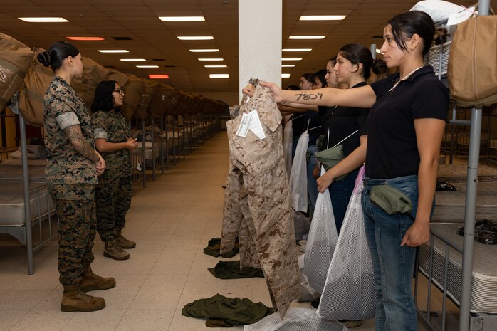 U.S. Marine Corps Cpl. Amanda Pimentel, a warehouse clerk with Headquarters and Service Battalion, briefs recruits with Lima Company, 3rd Recruit Training Battalion, during a receiving event at Marine Corps Recruit Depot San Diego, California, Oct. 21, 2024. During the receiving process, recruits are checked for contraband, given haircuts, make scripted phone calls home, and are issued gear required for training. (U.S. Marine Corps photo by Lance Cpl. Janell B. Alvarez)