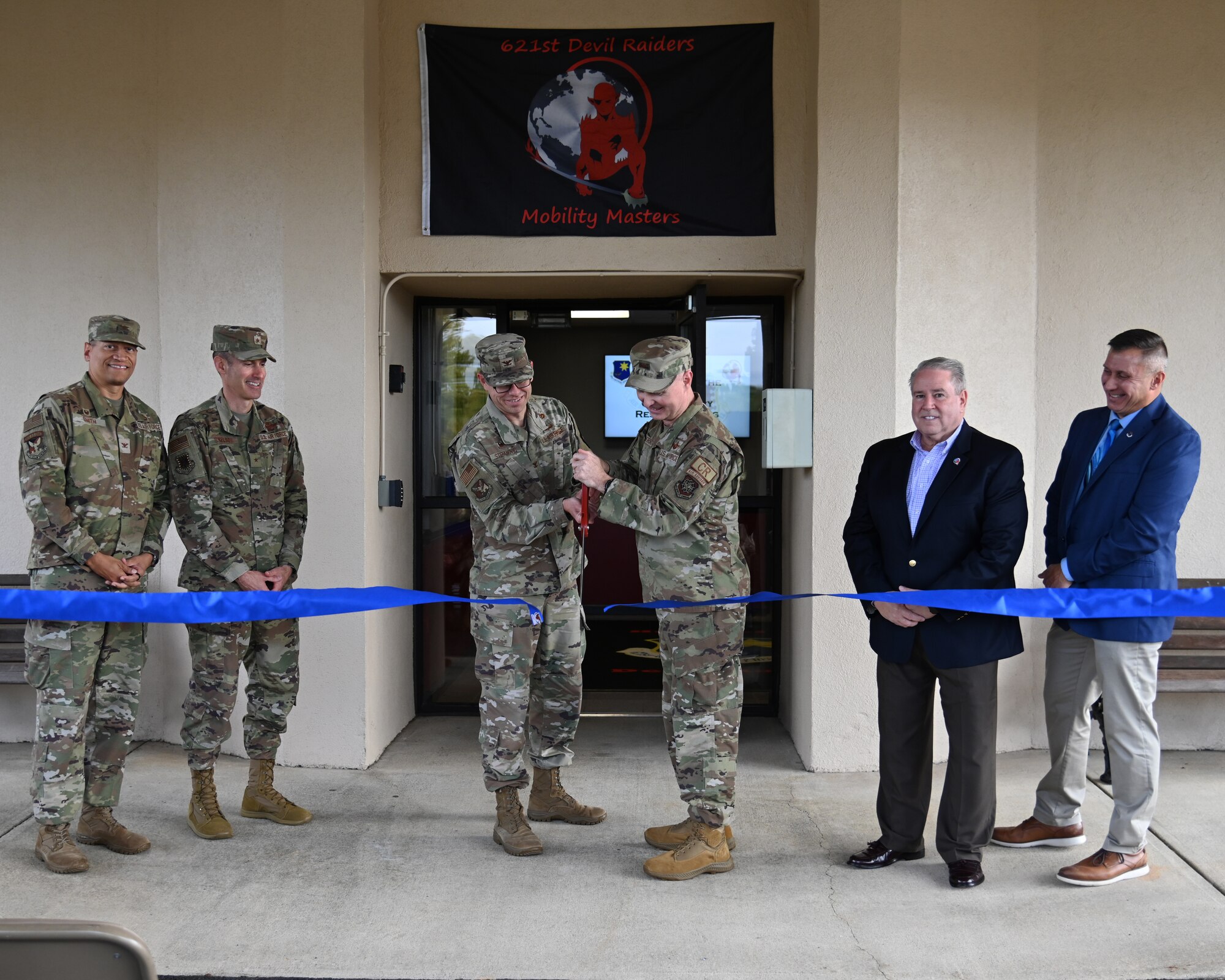 Brig. Gen. Stephen Snelson, U.S. Air Force Expeditionary Center commander, left, and Col. Jason Herring, 621st Contingency Response Wing commander, right, participate in a ribbon-cutting ceremony marking the official reopening of Building 1907 on Joint Base McGuire-Dix-Lakehurst, New Jersey, Oct. 2, 2024. The building had been previously under construction for nearly three years.